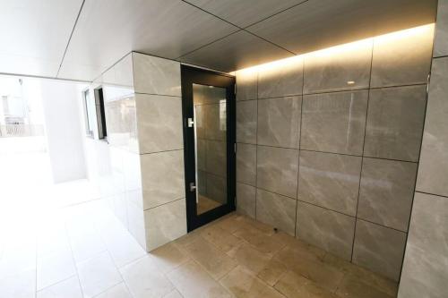 a bathroom with a walk in shower and a door at Stellar西糀谷 301 in Tokyo