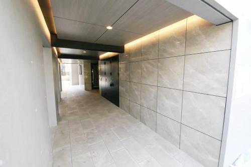 a hallway with a tile floor and a wall at Stellar西糀谷 301 in Tokyo