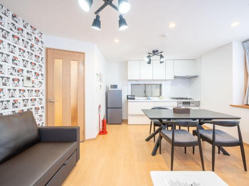 a living room with a table and chairs and a kitchen at Familia Omorikaigan in Tokyo