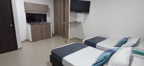 a hotel room with two beds and a flat screen tv at Hotel JARDIN PLAZA BY SGH in Cali