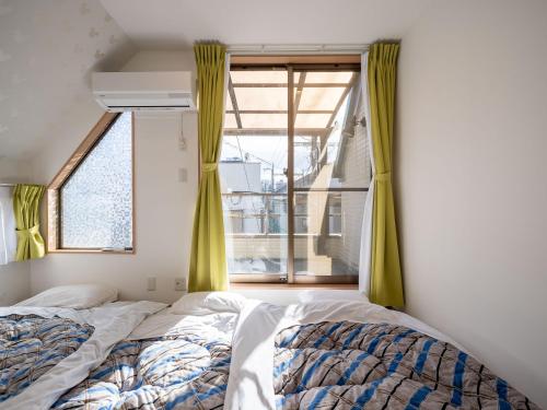 a bedroom with a bed and a window at Familia Omorikaigan in Tokyo