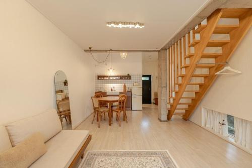 a living room with a staircase and a table at Jeju Byeolkkum Pension in Jeju