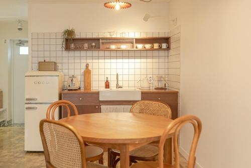 a kitchen with a table and chairs and a refrigerator at Jeju Byeolkkum Pension in Jeju