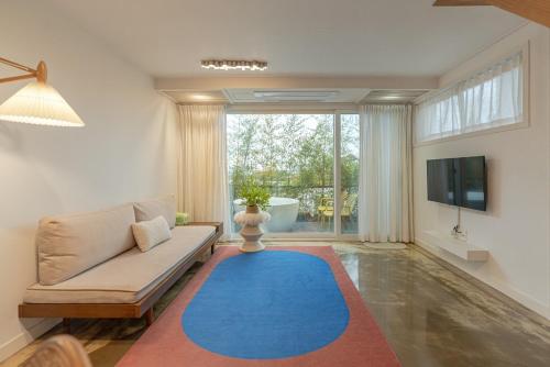 a living room with a couch and a blue rug at Jeju Byeolkkum Pension in Jeju
