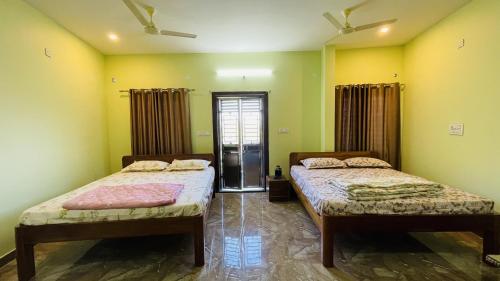 two beds in a room with yellow walls at Rashi Z View Estate Stay in Tarikere