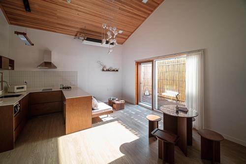 a room with a kitchen with a table and a window at Jeju Sinyeom-an-gil B in Jeju