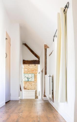 a living room with white walls and a wooden floor at The Old Coach House in Witney