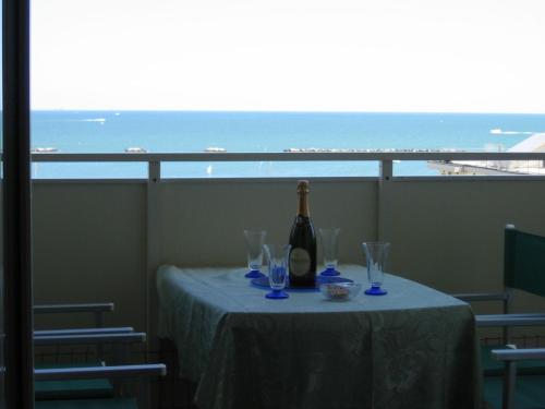 a table with a bottle of wine and glasses on a balcony at Miramare in Cesenatico
