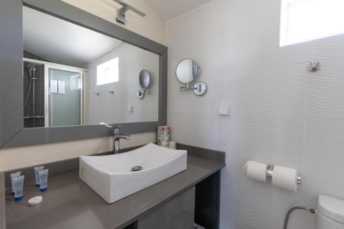 a bathroom with a white sink and a mirror at Canella Beach Hotel in Le Gosier
