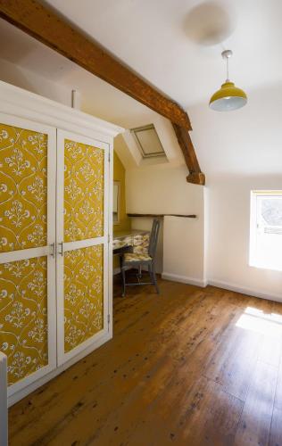 a living room with a table and a cabinet at The Old Coach House in Witney