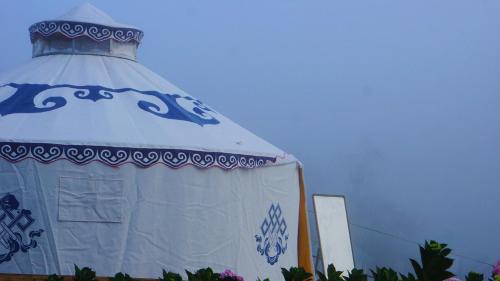 a white tent with a blue and white roof at Lưng Chừng House in Da Lat