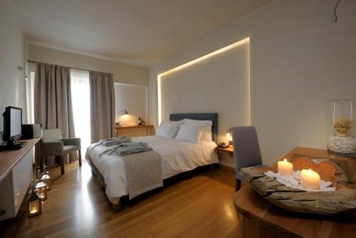 a bedroom with a bed and a table with candles at Valeni Boutique Hotel & Spa in Portariá