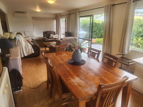 a kitchen and living room with a wooden table at Peppertree in Tauranga