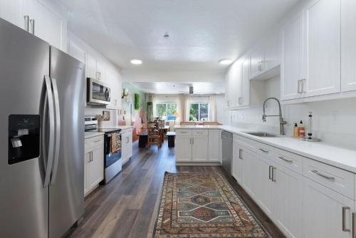 a kitchen with white cabinets and a stainless steel refrigerator at The Silver Spur in Hildale