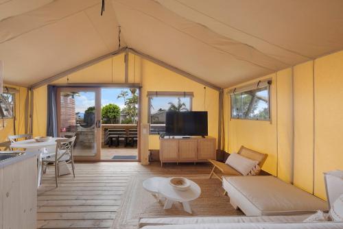 a living room with a couch and a tv at Reflections Bonny Hills - Holiday Park in Lake Cathie