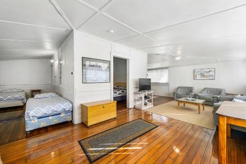 a living room with a bed a couch and a tv at Almare 7 Gowing Street in Crescent Head