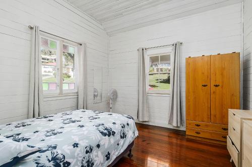 a bedroom with a bed and two windows at Almare 7 Gowing Street in Crescent Head