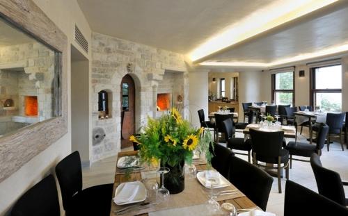 una sala da pranzo con tavolo e fiori di Valeni Boutique Hotel & Spa a Portariá