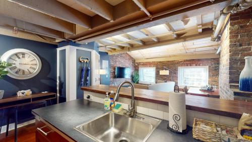 a kitchen with a sink and a clock on the wall at Elegant 2br 009mi Faneuil Hallquincy Market in Boston