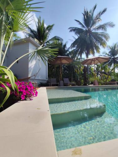 a pool at a resort with palm trees at O - HO Boutique Home in Baan Tai