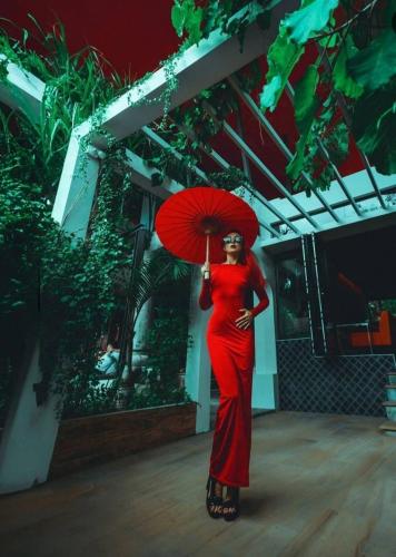a woman in a red dress holding a red umbrella at O - HO Boutique Home in Baan Tai