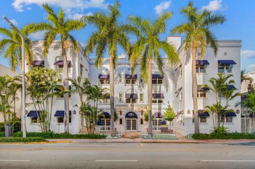a large white building with palm trees in front of it at Aloha Fridays in Miami Beach