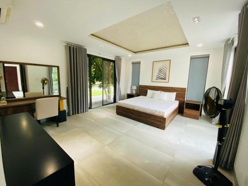 a bedroom with a bed and a desk and a sink at Swanbay - Hà Hoàng Villa in Cù Lao Ong Con