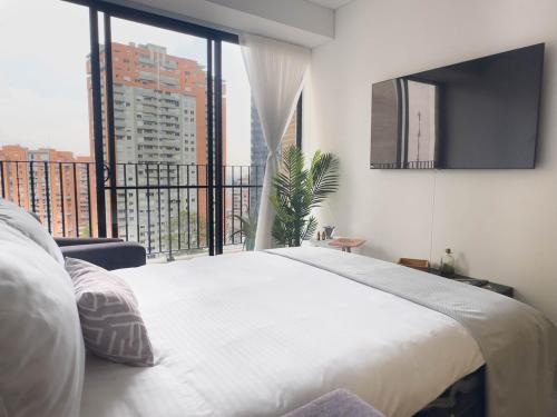 a bedroom with a large bed and a large window at Nuevo y Céntrico Apartamento in Bogotá