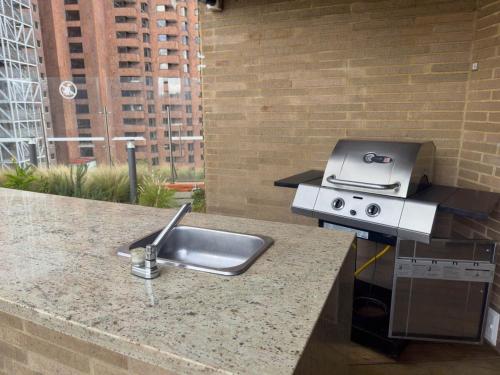 a kitchen counter with a sink and a grill at Nuevo y Céntrico Apartamento in Bogotá