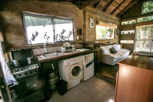 a kitchen with a sink and a washing machine at cabañas Piriapolis punta negra 099-66-35-44 in Punta Colorada