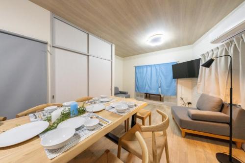 a dining room with a table and a couch at SORA usjまで電車で8分 5つの寝室 貸切の宿で楽しい時間を過ごしてください in Osaka