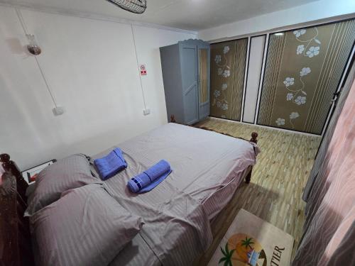 a bedroom with a bed with a blue pillow on it at Grand Baie Appartment Villa ii Cocotier in Grand Baie