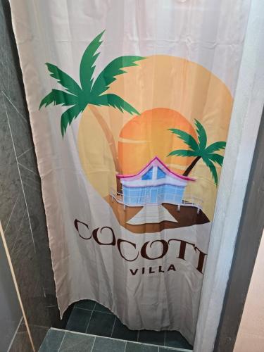a shower curtain with a palm tree and a corona sign at Grand Baie Appartment Villa ii Cocotier in Grand Baie