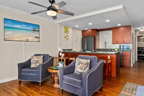 a living room with two chairs and a kitchen at 402 Kona Alii in Kailua-Kona