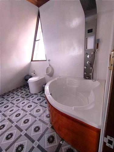 a bathroom with a large tub and a toilet at titicaca lodge jutma in Puno