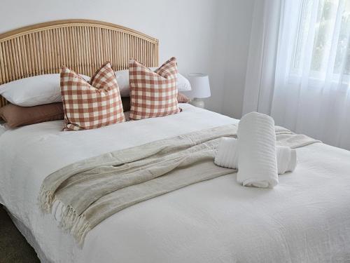 a white bed with pillows and a blanket on it at Olas Villa 4 - Plunge Pool & Walk to Beach in Anna Bay