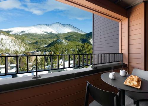 a balcony with a table and a view of mountains at Hotel Alpenrock Breckenridge, Curio Collection by Hilton in Breckenridge