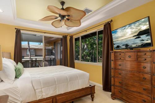 een slaapkamer met een plafondventilator en een dressoir bij 2001 Fairways at Mauna Lani in Waikoloa
