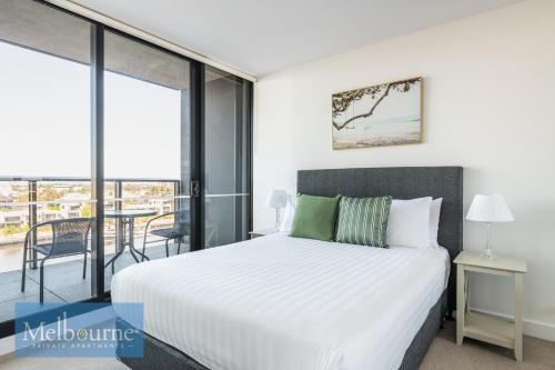 a bedroom with a bed and a balcony at Melbourne Private Apartments - Collins Wharf Waterfront, Docklands in Melbourne