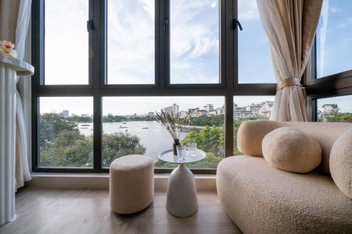 a living room with a large window with a couch and a table at Aimee House Homestay Trấn Vũ in Hanoi