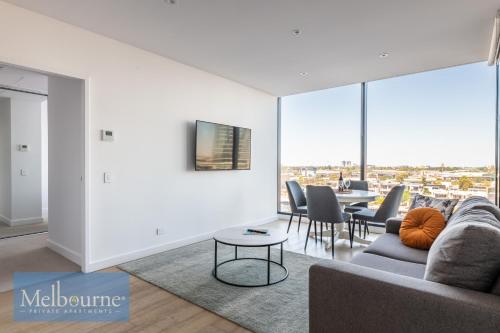 a living room with a couch and a table with chairs at Melbourne Private Apartments - Collins Wharf Waterfront, Docklands in Melbourne