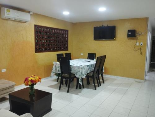 a dining room with a table and chairs and a tv at Green House in Cartagena de Indias