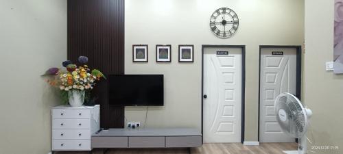 a living room with a tv on a wall at Homestay Villa H with POOL in Kuala Terengganu
