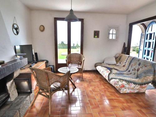 un salon avec un canapé et une cheminée dans l'établissement Maison en bord de mer avec jardin arboré à Groix - FR-1-813-17, à Groix