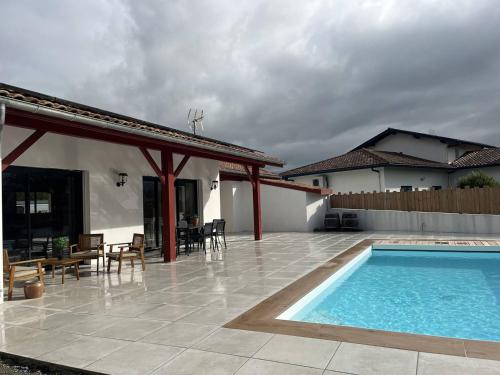 un patio avec une piscine et une maison dans l'établissement Cambo-les-Bains : Maison 3 Pièces, Piscine Privée, Internet, Parking - FR-1-495-148, à Cambo-les-Bains