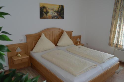 a bed with two pillows on it in a room at Hotel Haus Rameil in Lennestadt