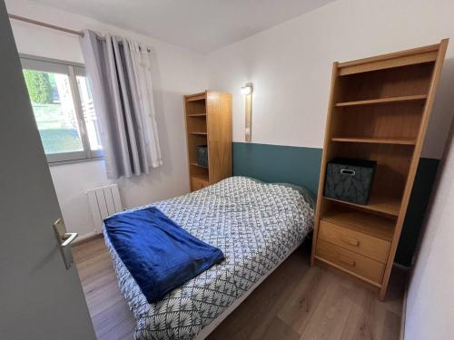- une petite chambre avec un lit et une étagère dans l'établissement Appartement rénové avec parking à Cauterets - FR-1-812-128, à Cauterets