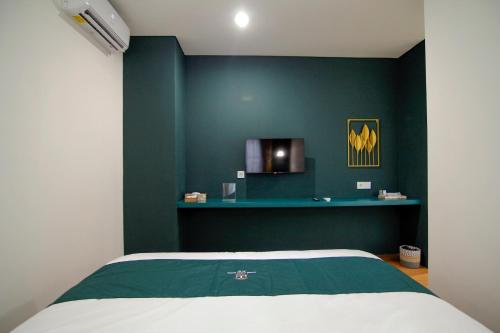 a bedroom with a green wall and a bed at Agung Guest House by RF in Timuran