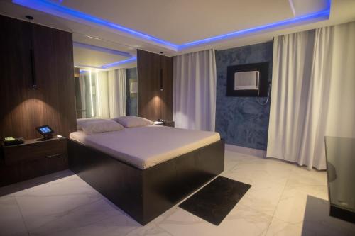 a bedroom with a bed with a blue lighting at Motel Caricia (Adult Only) in Rio de Janeiro