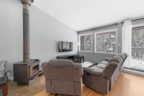 a living room with a couch and a stove at L'Adirondacks in Stoneham